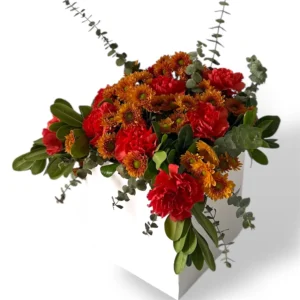 Autumn Ember floral arrangement with red carnations, bronze chrysanthemums, and fresh greenery