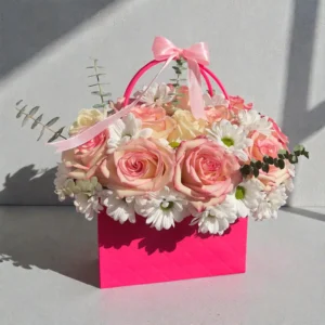 Blush pink rose bloom box with white daisies, eucalyptus greenery, and ribbon handle