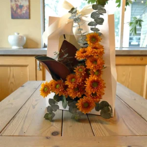 Orange chrysanthemum floral arrangement with eucalyptus in a white gift box