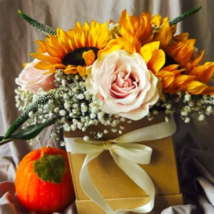 Golden sunflower arrangement with blush pink rose, baby’s breath, ivory ribbon, and autumn pumpkin