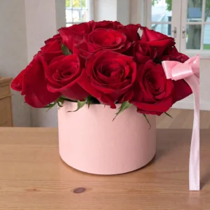Ruby Romance red rose arrangement in a pink hat box with ribbon